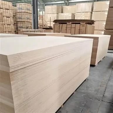 Large inventory of light-colored MDF boards in a warehouse